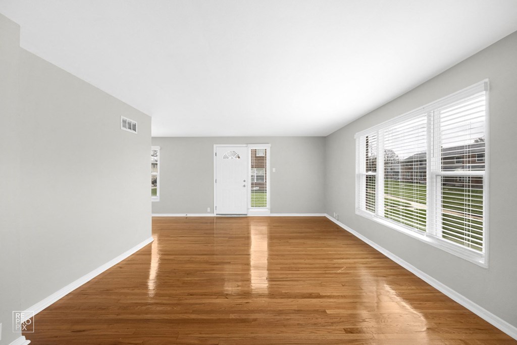 a bedroom with hardwood floors and grey walls