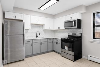 a kitchen with white cabinets and black appliances