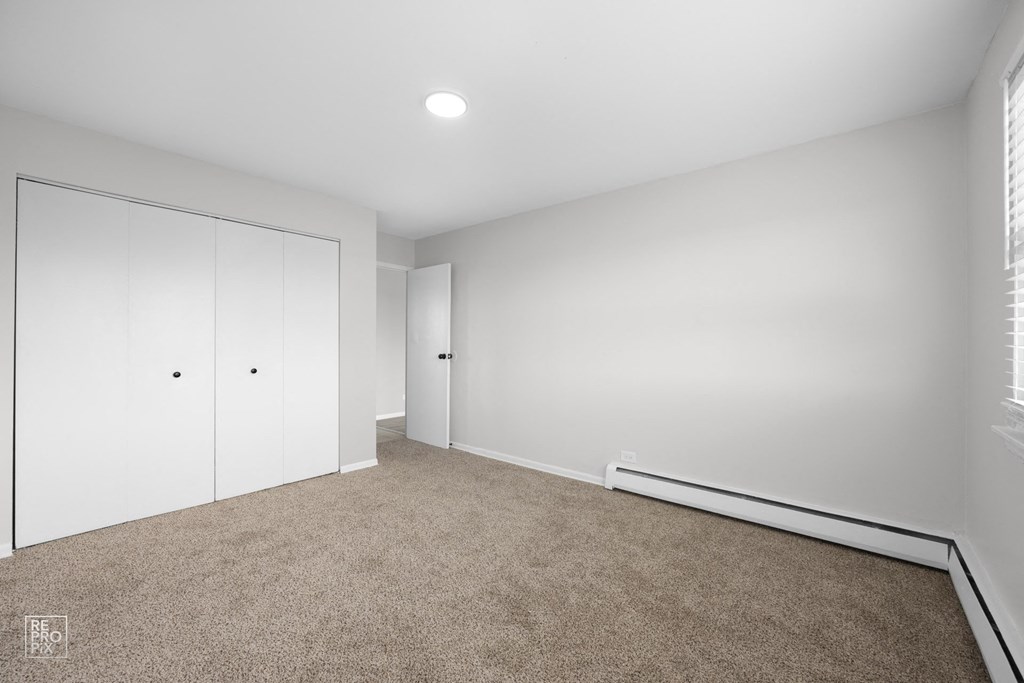 a bedroom with white walls and carpet