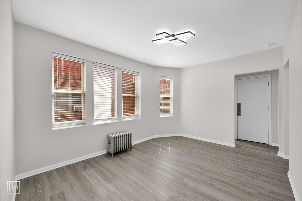 a bedroom with hardwood floors and grey walls