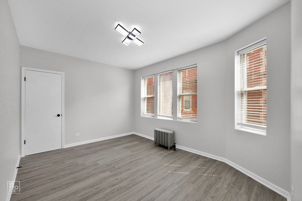 a bedroom with hardwood floors and grey walls