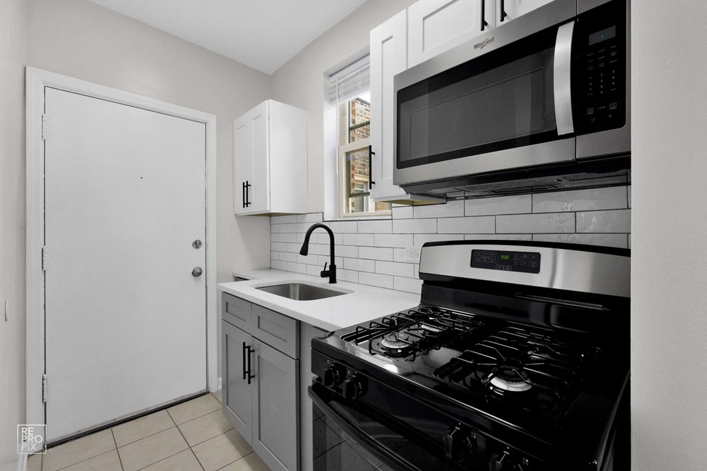 a kitchen with white cabinets and a black stove top oven