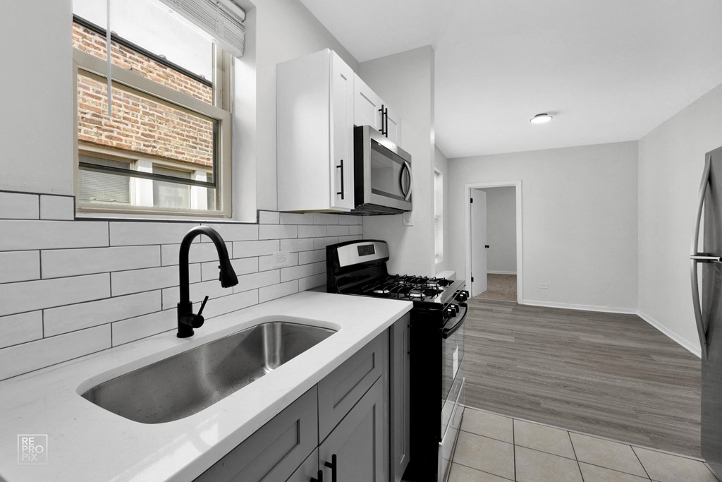 a kitchen with white cabinets and a black stove top oven