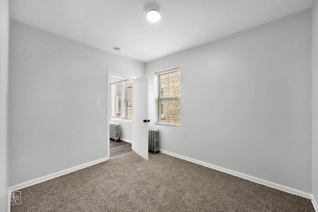 a bedroom with grey walls and carpet