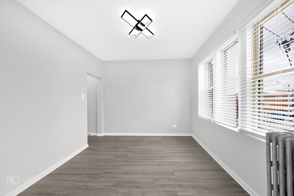 a bedroom with grey walls and a hardwood floor