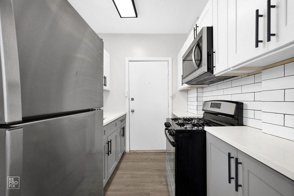 a kitchen with white cabinets and stainless steel appliances