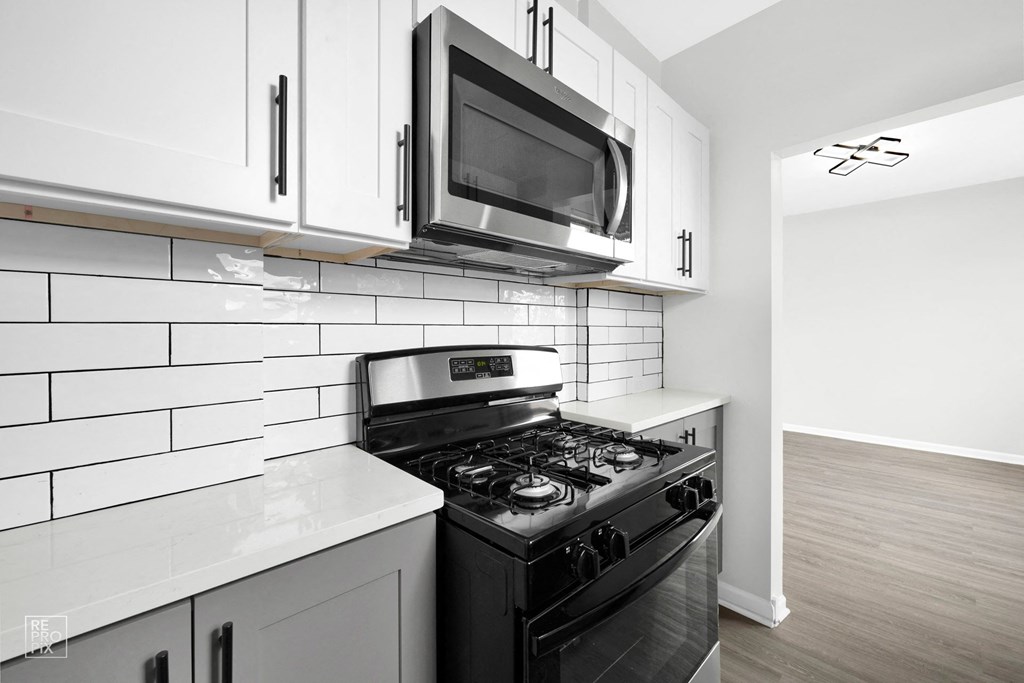 a kitchen with white cabinets and a black stove top oven