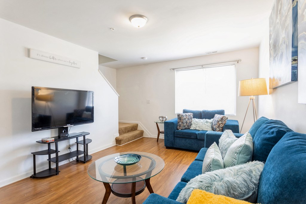 a living room with a blue couch and a television