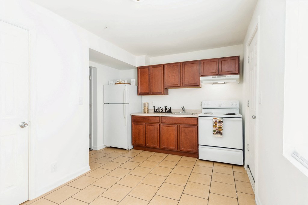 a kitchen with white appliances and wooden cabinets
