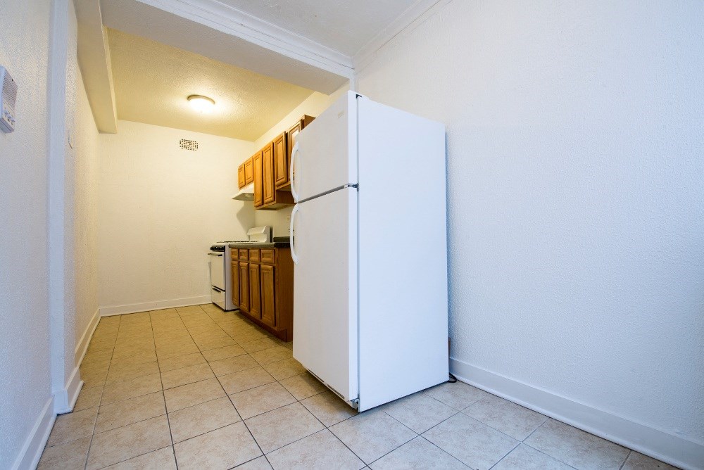a kitchen with a white refrigerator and cabinets