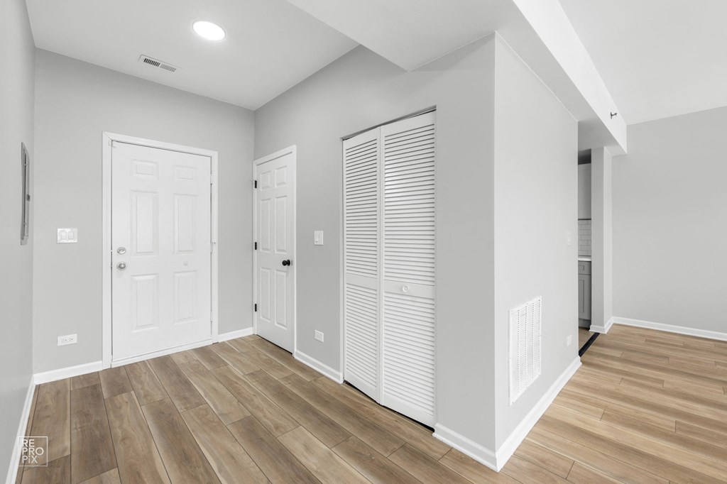 a bedroom with two doors and a hardwood floor