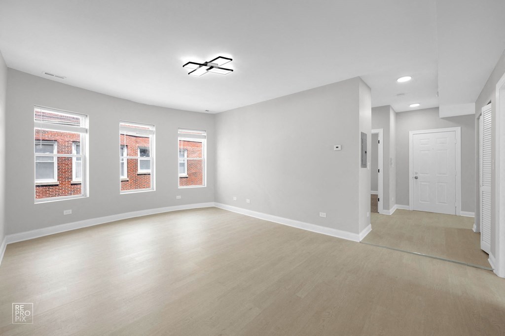 an empty living room with a white door and white walls