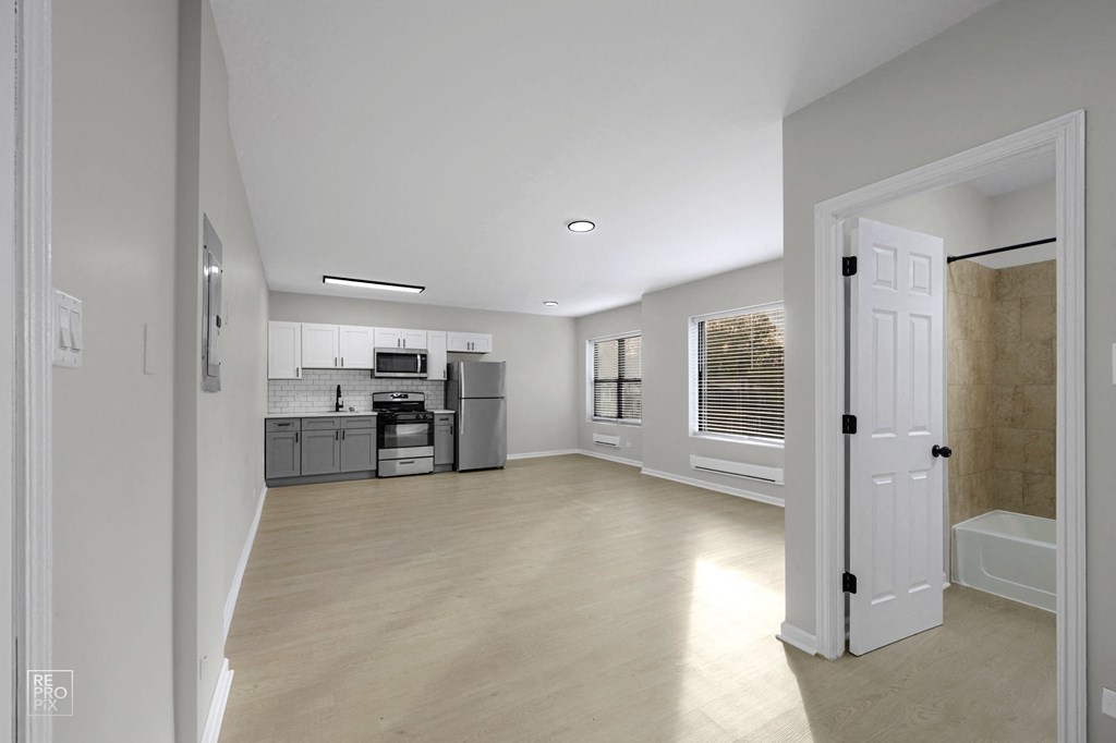 a bedroom with a medium sized bed and a doorway leading to a bathroom with a sink and