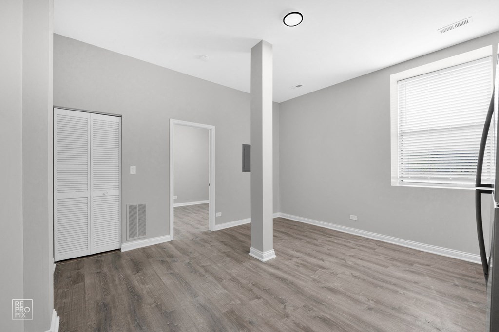 a bedroom with hardwood floors and grey walls
