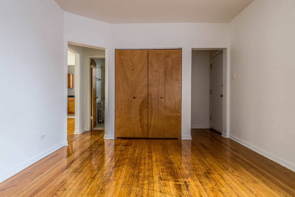 a empty room with a wooden floor and a wooden door