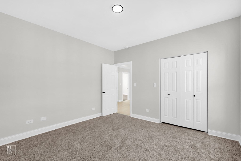 a bedroom with two doors and a carpeted floor