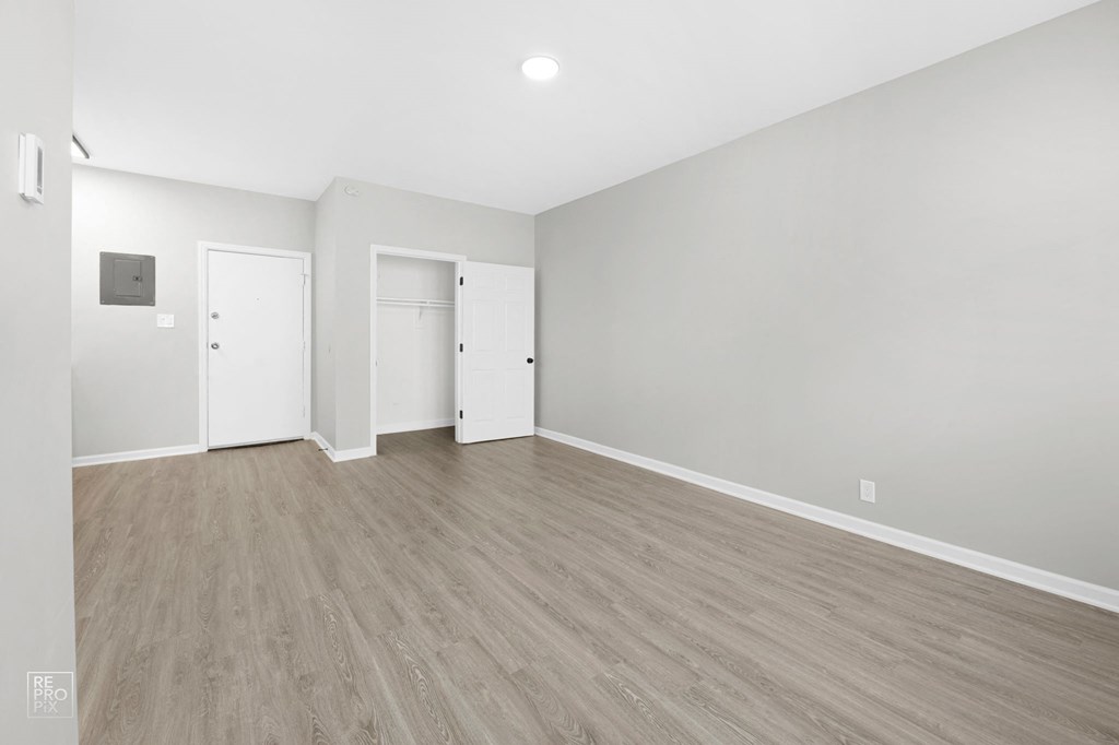 a bedroom with hardwood floors and grey walls