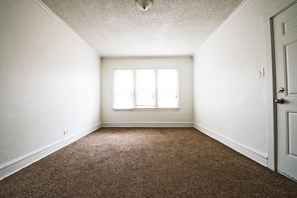 an empty room with carpet and a window