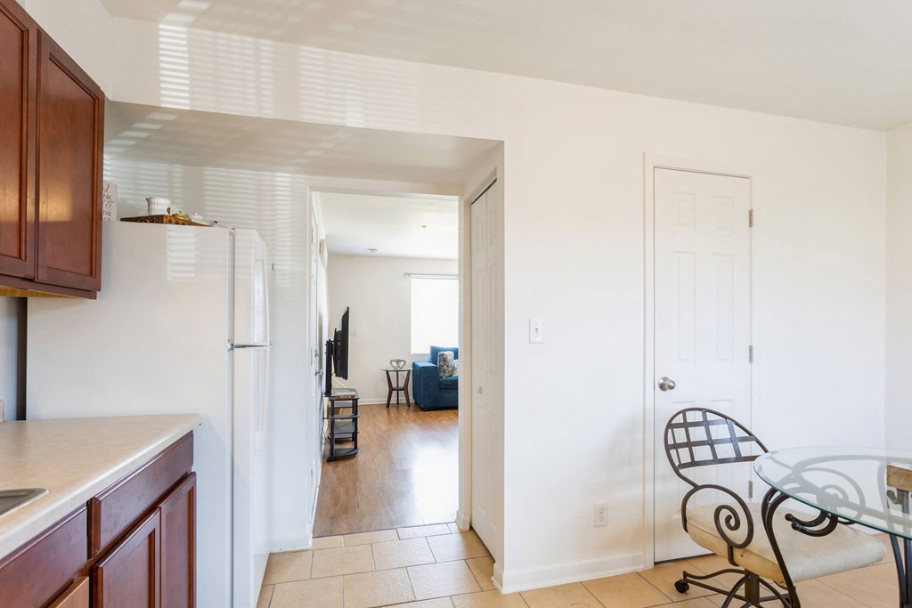a kitchen with a glass table and a refrigerator     and a door