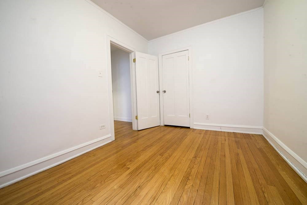 an empty room with wood floors and white walls