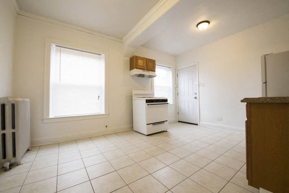 an empty kitchen with a stove and a refrigerator