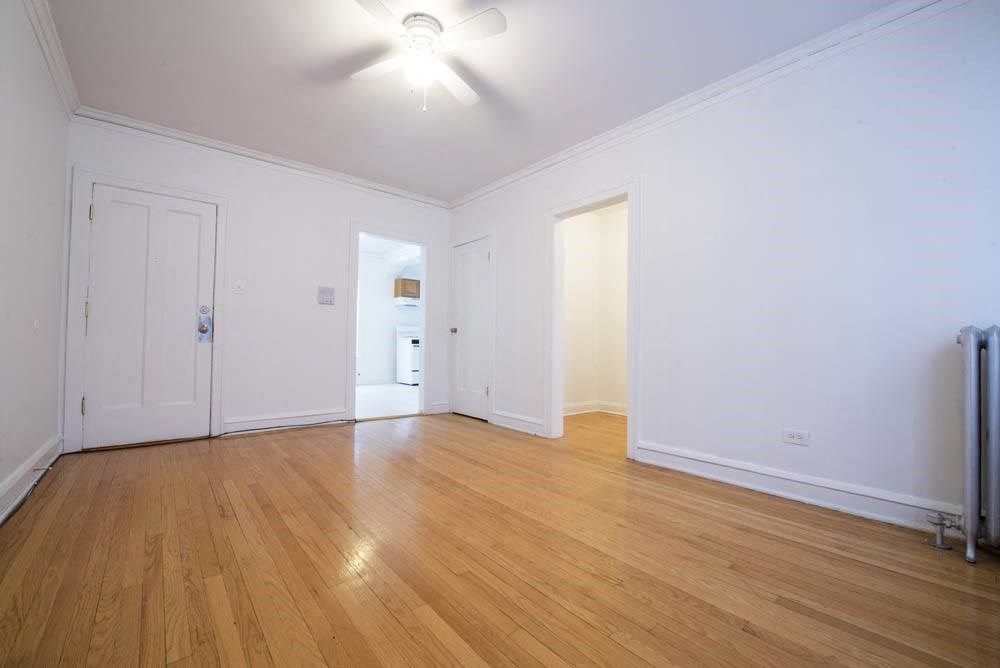 an empty living room with white walls and wood floors