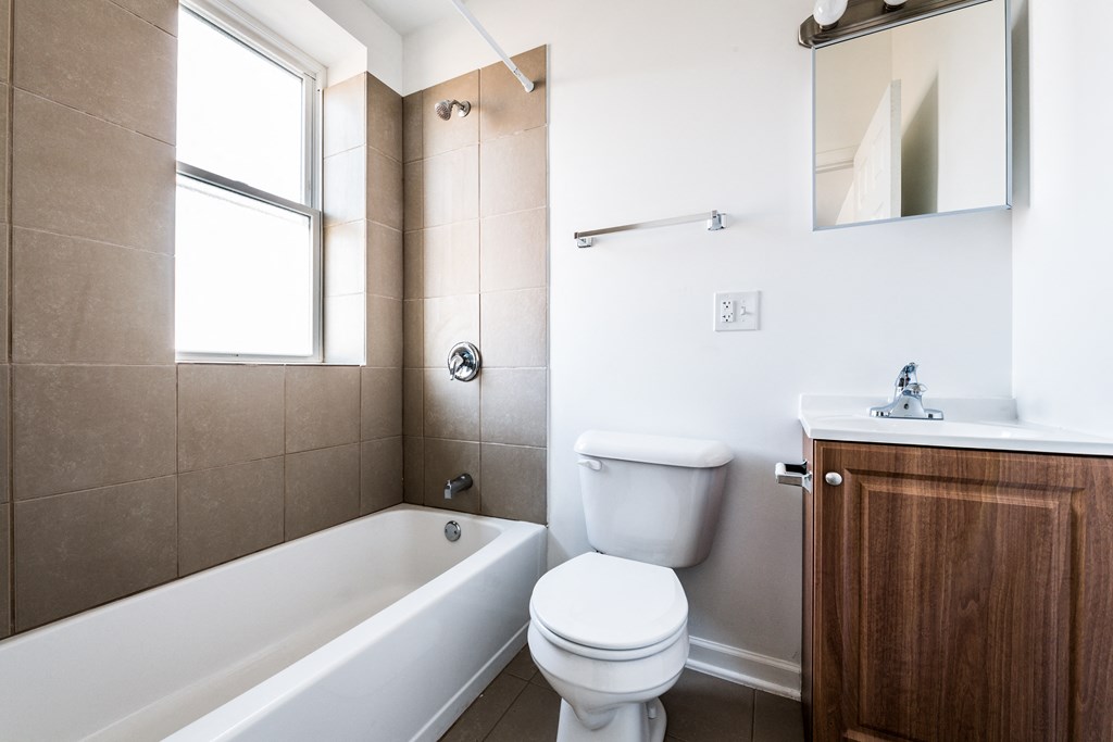 a bathroom with a toilet and a tub and a sink