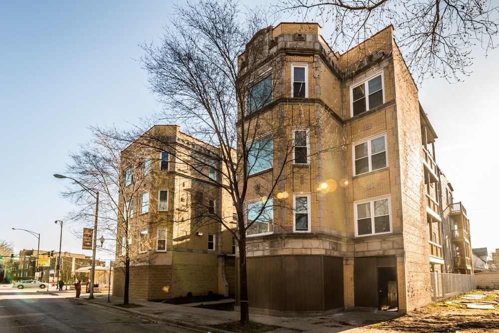 a brick building with a car garage in front of it