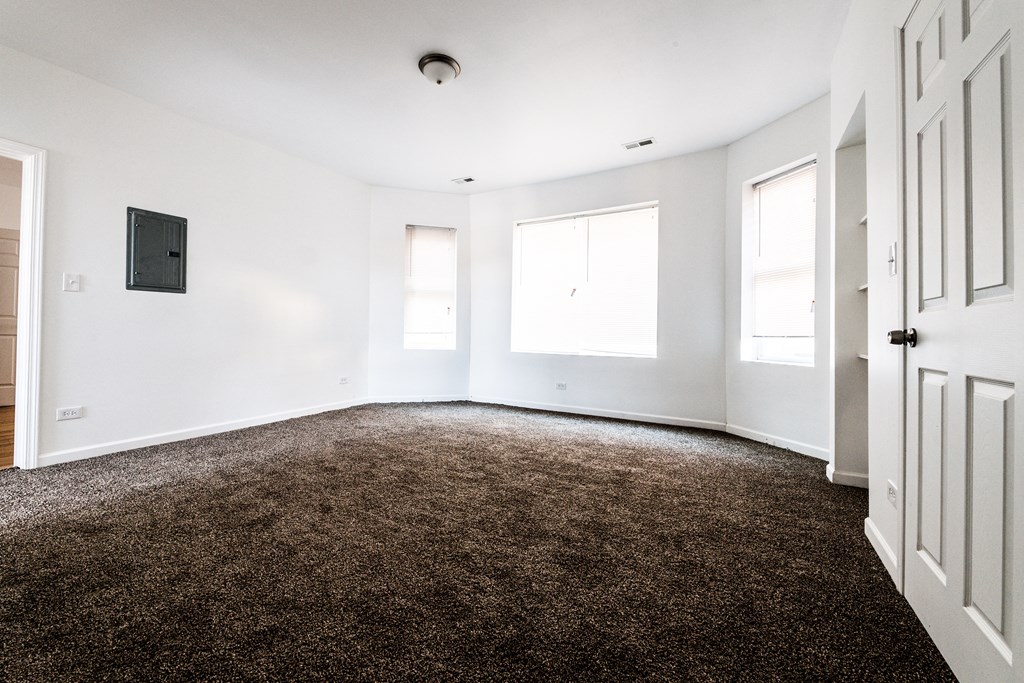 an empty room with white walls and a brown carpet