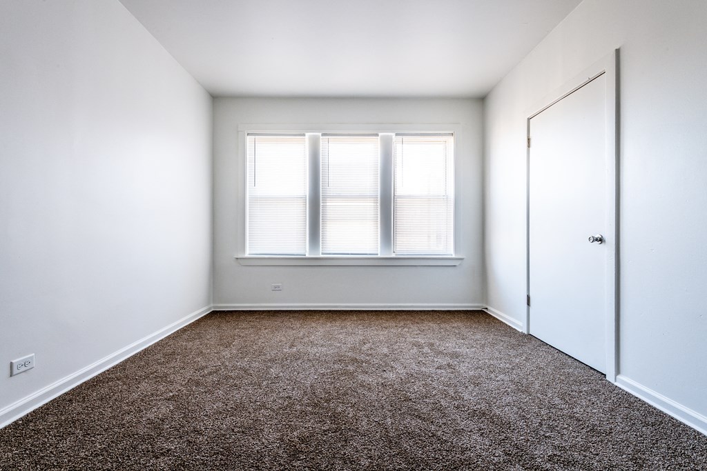 an empty room with a window and a door