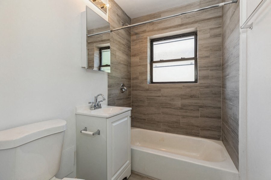 a bathroom with a toilet sink and tub and a window