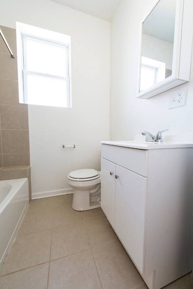 a white bathroom with a toilet and a sink