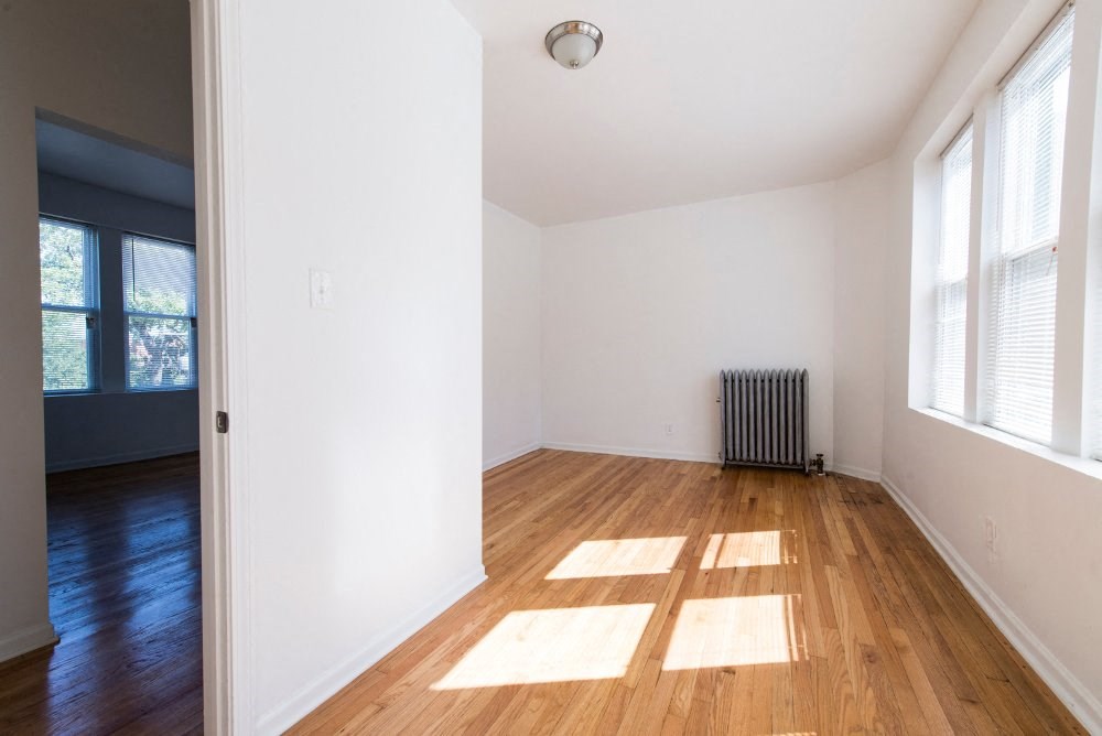 a living room with a hard wood floor and a radiator