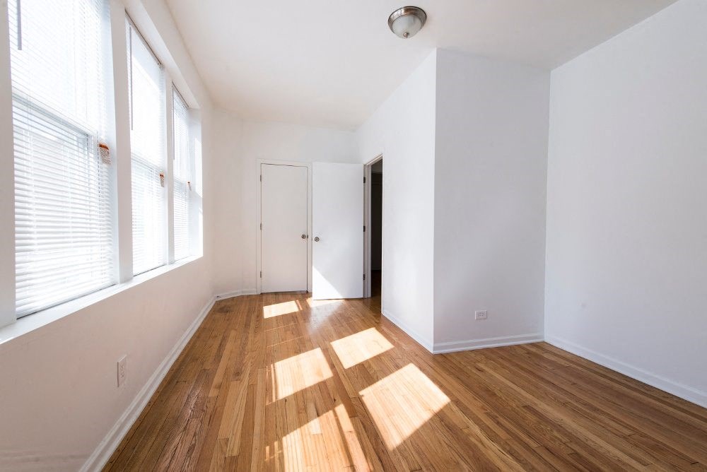 a living room with white walls and wood floors