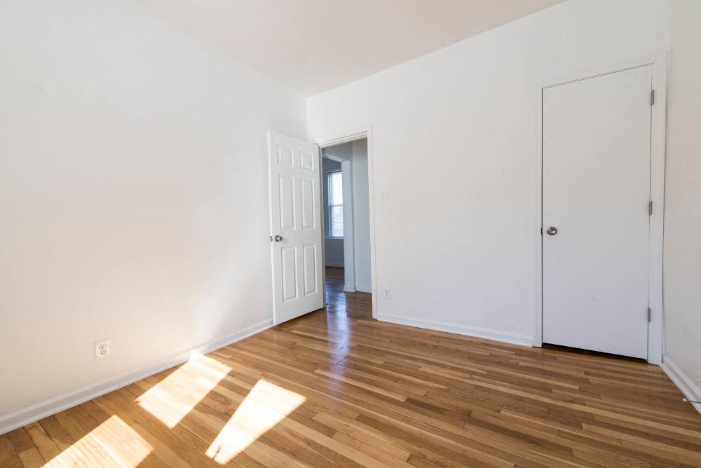 a living room and a hallway with white walls and wood floors