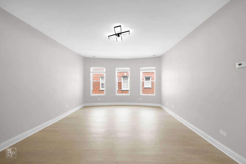 a large empty room with white walls and a wooden floor