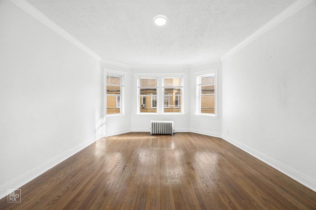 an empty living room with wood floors and windows