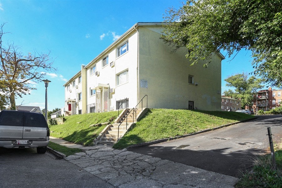 an apartment building with a van parked in front of it
