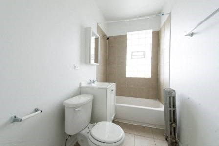 a white bathroom with a toilet and a bath tub