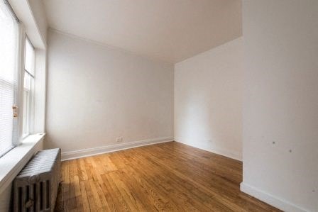a living room with a wood floor and a window