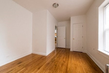 an empty living room with white walls and wooden floors