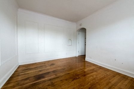 a empty room with white walls and wooden floors