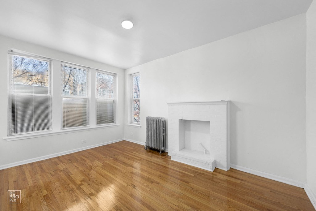 a living room with white walls and a fireplace