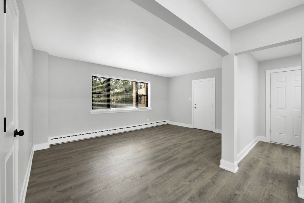 a bedroom with hardwood floors and white walls