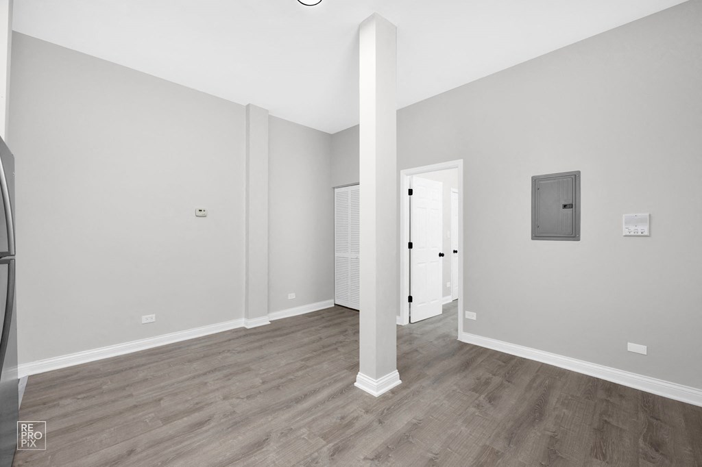 a bedroom with hardwood floors and grey walls