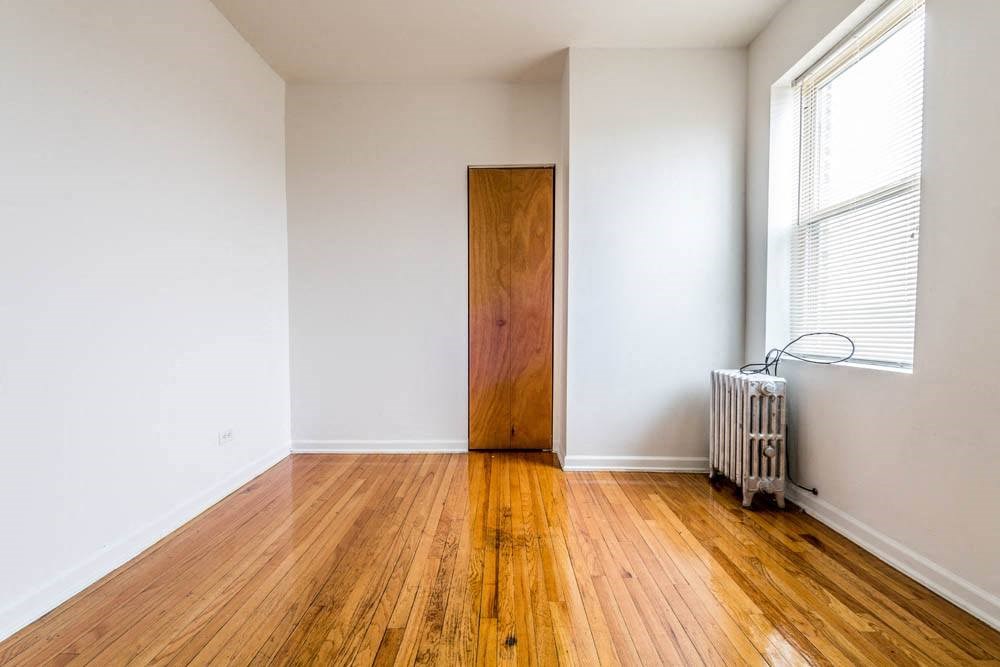 an empty room with wooden floors and a wooden door