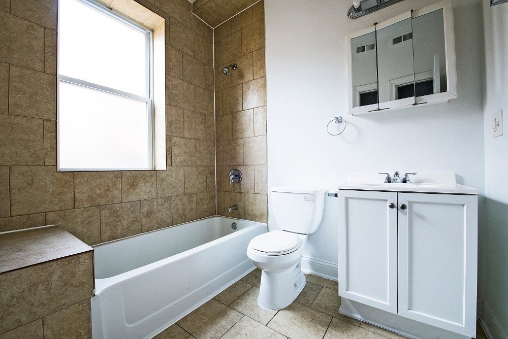 a bathroom with a toilet and a tub and a sink