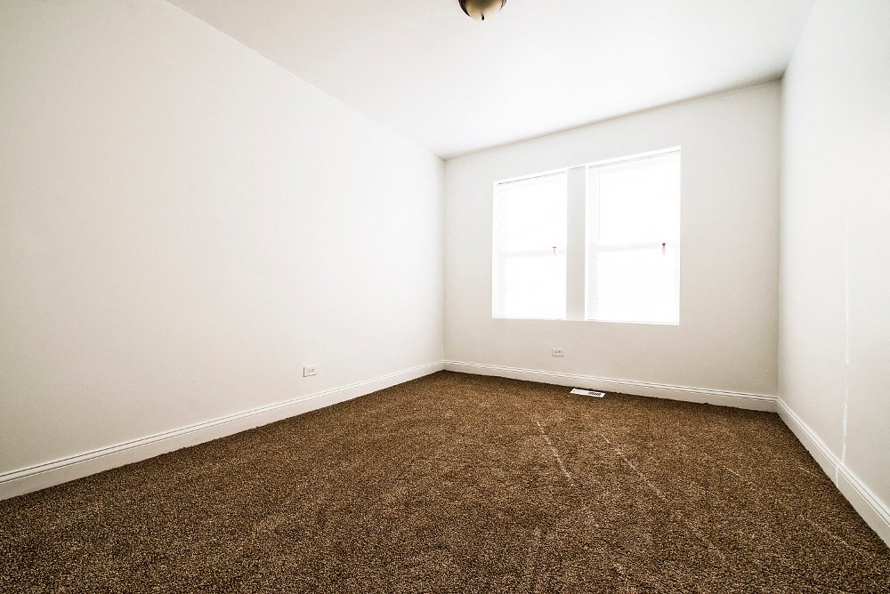 an empty room with carpet and a window