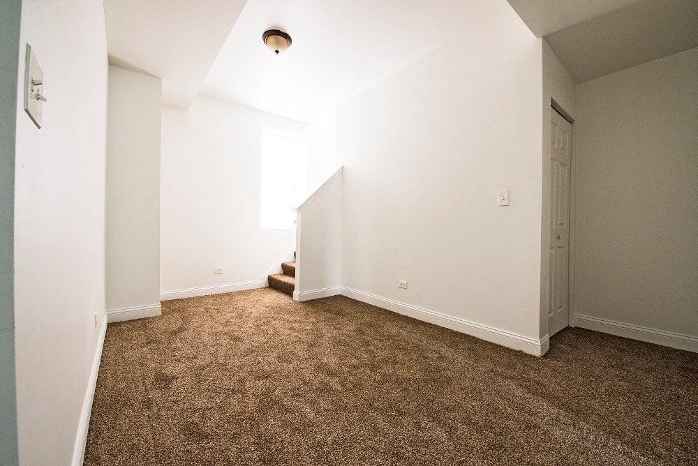 an empty room with a carpeted floor and a door to a closet