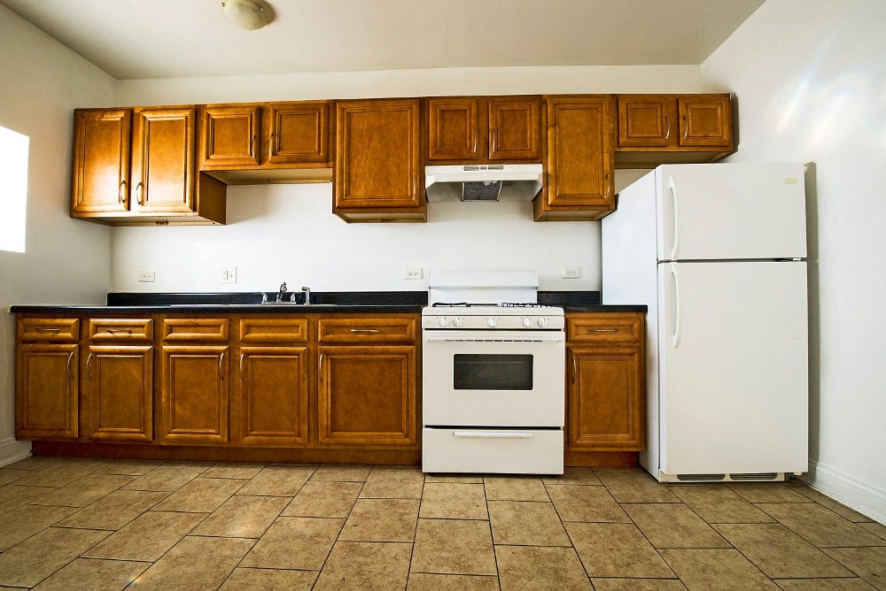 a kitchen with white appliances and wooden cabinets and a refrigerator